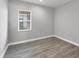 This bedroom features a window that lets in ample natural light, and grey wood-look floors at 10217 Canaveral Cir, Sarasota, FL 34241