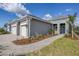 Front exterior showcases modern architectural design, manicured landscaping, and brick pathway to the front door at 10217 Canaveral Cir, Sarasota, FL 34241