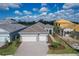 Aerial view of a gray single-Gathering home showcasing a well-manicured lawn and a brick driveway at 10217 Canaveral Cir, Sarasota, FL 34241