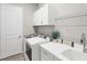 Bright laundry room features lots of counter space, a sink, overhead storage, and modern appliances at 10217 Canaveral Cir, Sarasota, FL 34241