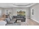 Open-concept living room features modern sectional sofa, neutral colors, and views of the lake at 10217 Canaveral Cir, Sarasota, FL 34241