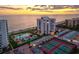 Aerial view of a condo community with a pool, tennis courts, and beachfront access at 1050 Longboat Club Road # 903, Longboat Key, FL 34228