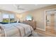 Bedroom features neutral decor, sliders to balcony with a water view, dresser, and ceiling fan at 1050 Longboat Club Road # 903, Longboat Key, FL 34228