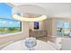 Bright dining area with ocean view, designer lighting, and elegant furnishings at 1050 Longboat Club Road # 903, Longboat Key, FL 34228