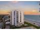 Exterior view of beachfront condo building overlooking ocean, pool, and beach at 1050 Longboat Club Road # 903, Longboat Key, FL 34228