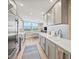 Bright kitchen features stainless steel appliances, light countertops, and view to breakfast nook near a window at 1050 Longboat Club Road # 903, Longboat Key, FL 34228