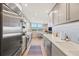 Bright kitchen features stainless steel appliances, light countertops, and view to breakfast nook near a window at 1050 Longboat Club Road # 903, Longboat Key, FL 34228