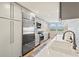 Bright kitchen features stainless steel appliances, light countertops, and view to breakfast nook near a window at 1050 Longboat Club Road # 903, Longboat Key, FL 34228
