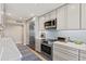 Modern kitchen with stainless steel appliances, quartz countertops, and custom cabinets at 1050 Longboat Club Road # 903, Longboat Key, FL 34228