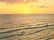 Golden hour at the beach with a lone surfer in the waves at 1050 Longboat Club Road # 903, Longboat Key, FL 34228