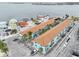 A sunny aerial view shows the turquoise apartment complex near a large bay and ample parking space at 117 7Th N St # 5, Bradenton Beach, FL 34217