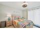 Bright bedroom with a colorful striped comforter, ceiling fan, and access to the balcony at 117 7Th N St # 5, Bradenton Beach, FL 34217