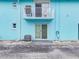 Exterior view of light blue property with sliding glass doors, balcony and AC units at 117 7Th N St # 5, Bradenton Beach, FL 34217