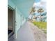 A long exterior shot features many apartment doors, a stairwell and palm trees at 117 7Th N St # 5, Bradenton Beach, FL 34217