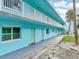 Picture of pastel blue condo, showcasing a simple design with a gray walkway and metal safety rail balcony at 117 7Th N St # 5, Bradenton Beach, FL 34217