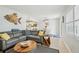 Cozy living area with a comfortable gray sectional, unique coffee table, and an open view to the kitchen at 117 7Th N St # 5, Bradenton Beach, FL 34217