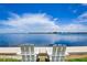 Relaxing waterfront view with two white Adirondack chairs on the water at 117 7Th N St # 5, Bradenton Beach, FL 34217