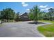 Large barn with a paved driveway, surrounding greenery, and a picturesque setting at 12615 River Rd, Myakka City, FL 34251