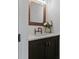 Powder room featuring dark wood vanity, copper faucet, marble countertop, and framed mirror with modern sconce at 12615 River Rd, Myakka City, FL 34251
