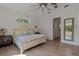 Well-lit bedroom featuring hardwood flooring, a ceiling fan, and a mirror at 12615 River Rd, Myakka City, FL 34251