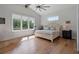 Comfortable bedroom with a ceiling fan, large windows, and hardwood flooring at 12615 River Rd, Myakka City, FL 34251