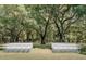 Serene outdoor wedding venue featuring rows of white chairs under majestic, moss-draped trees at 12615 River Rd, Myakka City, FL 34251
