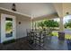Inviting outdoor space with wooden furniture, columns, and views of the well-maintained lawn at 12615 River Rd, Myakka City, FL 34251