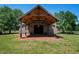 Elegant event barn with a brick patio and rustic wooden beam construction, surrounded by lush greenery at 12615 River Rd, Myakka City, FL 34251