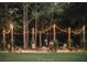 Enchanting evening fire pit area illuminated by string lights, creating a cozy and inviting atmosphere at 12615 River Rd, Myakka City, FL 34251