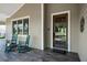 Close-up of a charming front porch with rocking chairs, wood flooring, and brick accents at 12615 River Rd, Myakka City, FL 34251