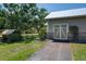 Garage with decorative doors and a paved driveway, set amidst a backdrop of mature trees and landscaping at 12615 River Rd, Myakka City, FL 34251