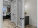 Hallway featuring herringbone-patterned floors leading to laundry room with gray cabinets and stainless steel appliances at 12615 River Rd, Myakka City, FL 34251