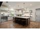Bright kitchen with a large center island, farmhouse sink, stainless steel appliances, and open shelving at 12615 River Rd, Myakka City, FL 34251