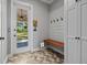 Mud room with a built-in bench, coat hooks, shiplap accent wall, access to the backyard, and herringbone floors at 12615 River Rd, Myakka City, FL 34251