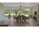 Covered outdoor dining patio with a ceiling fan and wood-look tile overlooks the backyard at 12615 River Rd, Myakka City, FL 34251