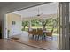 Covered outdoor dining patio featuring wood-look tile, ceiling fan and a view of the lush landscaping at 12615 River Rd, Myakka City, FL 34251