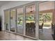 Expansive folding patio doors showcase the outdoor dining area and lush landscaping beyond at 12615 River Rd, Myakka City, FL 34251