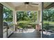 Outdoor patio with built-in grill, wood floors, brick columns, overlooking landscaped yard and mature trees at 12615 River Rd, Myakka City, FL 34251