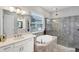 Bathroom featuring a soaking tub, glass-enclosed shower, and vanity with marble countertop at 13902 Messina Loop, Bradenton, FL 34211