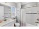 Bright bathroom with white vanity, framed mirror and shower with tile surround at 13902 Messina Loop, Bradenton, FL 34211