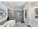 Bright bathroom featuring a soaking tub, glass-enclosed shower, and access to a walk-in closet at 13902 Messina Loop, Bradenton, FL 34211