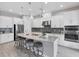 Modern kitchen with white cabinetry, stainless steel appliances, granite countertops, and a spacious center island at 13902 Messina Loop, Bradenton, FL 34211