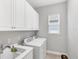 Well-equipped laundry room with sink, washer, dryer, and ample storage at 13902 Messina Loop, Bradenton, FL 34211
