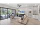A bright living room featuring neutral tones, a modern ceiling fan, and an outdoor patio at 13902 Messina Loop, Bradenton, FL 34211