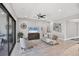 Bright living room featuring neutral tones, a modern ceiling fan, a decorative gallery wall, and a large window at 13902 Messina Loop, Bradenton, FL 34211