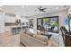 Bright living room with open floor plan to the modern kitchen and outdoor patio featuring bar stools at 13902 Messina Loop, Bradenton, FL 34211