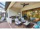 Comfortable covered patio with brick pavers, outdoor kitchen, ceiling fan, and outdoor seating at 13902 Messina Loop, Bradenton, FL 34211