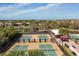 Image shows multiple pickleball courts with green surfaces, adjacent to a shaded seating area at 13902 Messina Loop, Bradenton, FL 34211