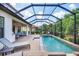 Screened-in pool and spa with brick pavers, lounge chairs, and covered patio area at 13902 Messina Loop, Bradenton, FL 34211