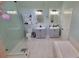Bright bathroom with dual sink vanity, tub/shower and separate toilet area at 1609 17Th W St, Bradenton, FL 34205